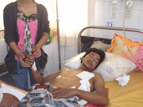 Dy Vichet, who was shot by a police officer in Phnom Penh's Russei Keo district on Sunday night, allegedly for not paying a bribe, recovers at Calmette Hospital on Monday. (Khy Sovuthy/The Cambodia Daily)