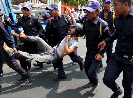 Municipal security guards carry Leng Chin to a waiting police truck during an anti-eviction demonstration in Phnom Penh on Wednesday. Rights groups criticized what they said was an excessive use of force against the protesters by security guards and police. (Siv Channa)