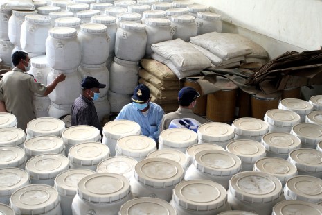 Police in Phnom Penh inspect barrels and bags full of chemicals on Wednesday, part of a 106-ton haul of substances that authorities say were to be used to manufacture illegal narcotics. (Siv Channa)
