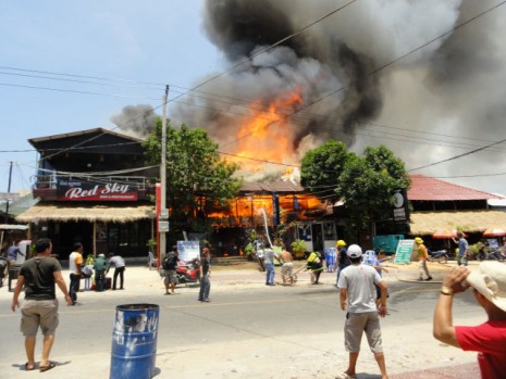 A fire engulfs a guesthouse along Serendipity Road in Sihanoukville on Sunday. A fleet of fire trucks struggled to extinguish the blaze, which destroyed four businesses, due to a severe water shortage in the area. (Hok Ly)