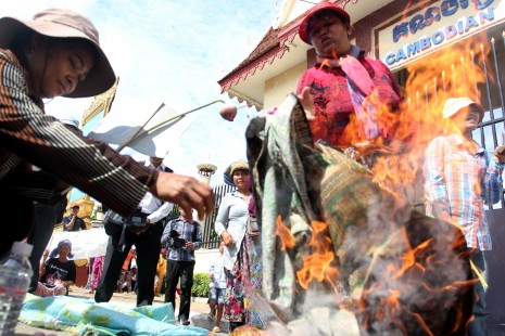 Anti-eviction protesters from three communities in Phnom Penh burn sarongs—a typical gift from parties at election time—outside the Cambodian People's Party headquarters on Monday. The protesters from Boeng Kak, Borei Keila and Thmar Kaul say they need homes, not sarongs, from Prime Minister Hun Sen's ruling party. (Siv Channa)