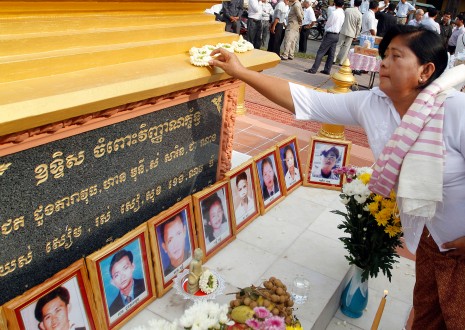 A mourner pays her respects to the 16 men, women and children who died in a grenade attack on a pro-democracy rally in 1997 at an event marking the 16th anniversary of the massacre on Saturday in Phnom Penh. (Siv Channa)