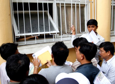 People wait outside the Central Post office in Phnom Penh to submit vehicle registration applications. The government has tried to stamp out corruption in the sector, but those waiting said the new process was inefficient and frustrating. (Siv Channa)
