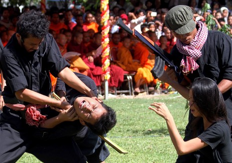 Students from the Royal University of Fine Arts re-enact scenes of Khmer Rouge-era killing at the Choeung Ek killing fields during the annual Day of Anger on Monday. (Siv Channa/The Cambodia Daily)
