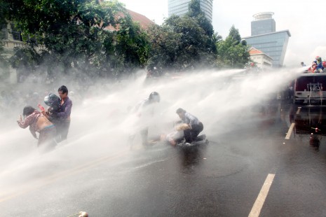 Phnom Penh firefighters use high-pressure water cannons Wednesday on a group of anti-eviction protesters blocking Monivong Boulevard to demand a meeting with city governor Pa Socheatvong. (Siv Channa)
