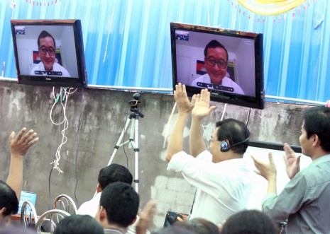 Cambodia National Rescue Party president Sam Rainsy speaks via video-link to supporters gathered at the party's Phnom Penh headquarters on Sunday. Blocked from traditional media, the opposition is trying to spread its message by using social networking websites. (Siv Channa)