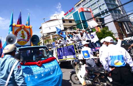 Supporters of the CPP and the Cambodia National Rescue Party (CNRP) pass each other Thursday in Phnom Penh on the first day of the official national election campaign. (Lauren Crothers/The Cambodia Daily)