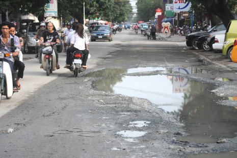 Motorists make their way down Phnom Penh's potholed Street 63 on Monday. (Simon Henderson/The Cambodia Daily)