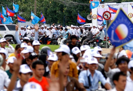 Supporters of the Cambodia National Rescue Party, foreground, rally on motorcycles in front of Wat Botum park Tuesday as hundreds of young CPP supporters, background, hold their own campaign event nearby. (Siv Channa)