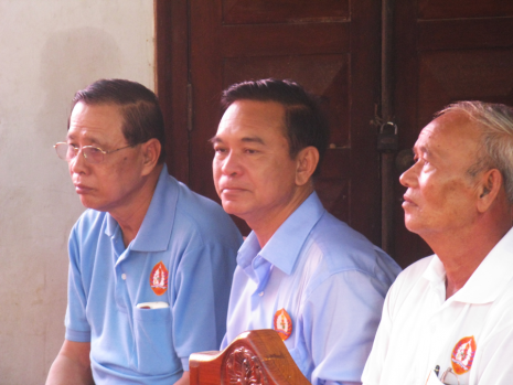 Police Major General Kem Sokhon, the brother of opposition leader Kem Sokha, sits between CPP candidates for National Assembly at a ruling party rally in Prey Veng province yesterday. (Colin Meyn/The Cambodia Daily) 