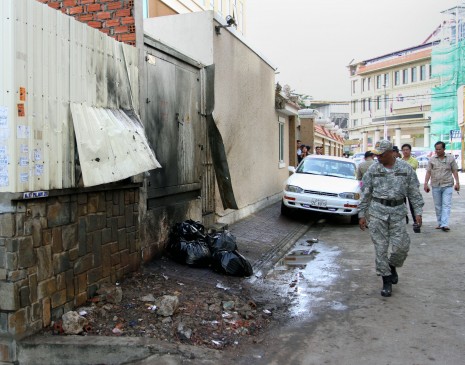 A military officer walks past the site of Wednesday morning's bomb explosion outside the Phnom Penh Municipal Court on Street 213. No one was injured in the blast. (Siv Channa)