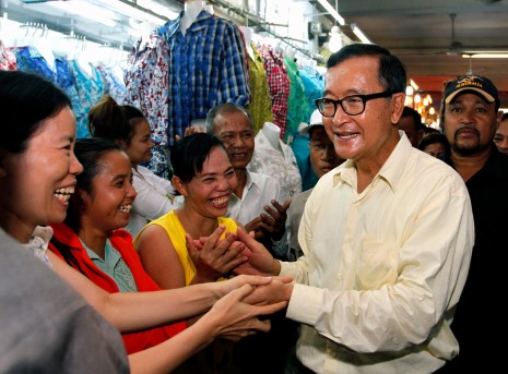 Opposition party president Sam Rainsy visits shoppers and vendors at Phnom Penh's Olympic Market on Friday in an attempt to generate support ahead of a large CNRP rally scheduled for Monday at Freedom Park. (Siv Channa)