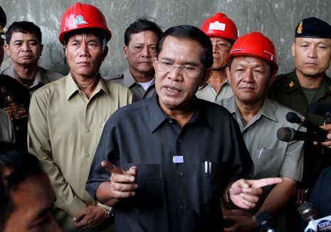 Prime Minister Hun Sen speaks with reporters Wednesday at a construction site for an overpass in Phnom Penh's Meanchey district, his first public appearance since Sunday's national election. (Siv Channa)