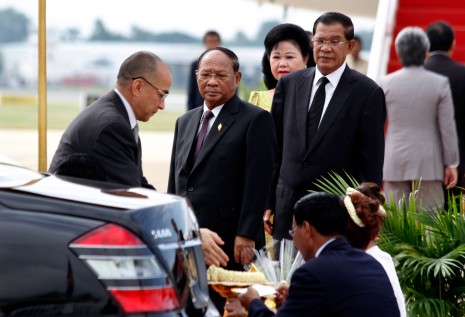King Norodom Sihamoni, left, is presented with a garland of jasmine before boarding a plane to Beijing on Monday as National Assembly President Heng Samrin, second from left, Prime Minister Hun Sen and his wife, Bun Rany, bid him farewell. King Sihamoni is going to China for a routine medical checkup and said he will return in time to open the National Assembly for the government's next mandate. (Siv Channa)