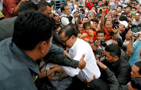 CNRP security guards lift opposition leader Sam Rainsy onto a stage on Monday at Phnom Penh's Freedom Park, where he addressed more than 10,000 supporters. (Siv Channa)