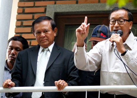 Opposition president Sam Rainsy, right, delivers a speech alongside his deputy, Kem Sokha, to a crowd of about 1,000 supporters at the party's headquarters in Phnom Penh on Wednesday. (Siv Channa)