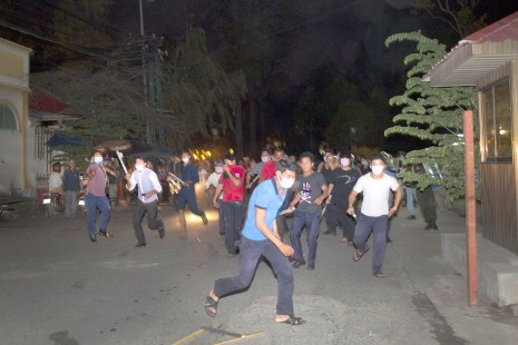 A civilian mob flanked by riot police and armed with Tasers, slingshots and sticks chase after Boeng Kak activists and journalists near Wat Phnom on Sunday night.