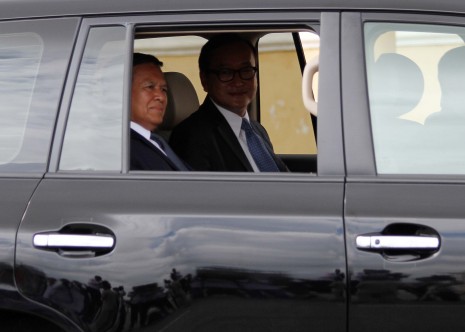 CNRP leaders Sam Rainsy, right, and Kem Sokha arrive at the Royal Palace on Saturday morning for a meeting with King Norodom Sihamoni and a CPP delegation led by Prime Minister Hun Sen. (Siv Channa)