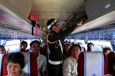 A military police officer searches a bus for weapons Thursday at a checkpoint on National Road 5 in Phnom Penh's Russei Keo district. Authorities have set up checkpoints along all major roads leading into the city in advance of Saturday's opposition-led demonstration against voting irregularities in July's national election. (Siv Channa)