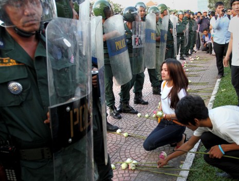 On the eve of the CNRP protest in Phnom Penh, members of the Youth for Peace group present lotus flowers to riot police near the Ministry of Defense on Friday. The youth group had planned to distribute the flowers as a peace offering to members of the ministry's armed forces but the police blocked their route. (Siv Channa)