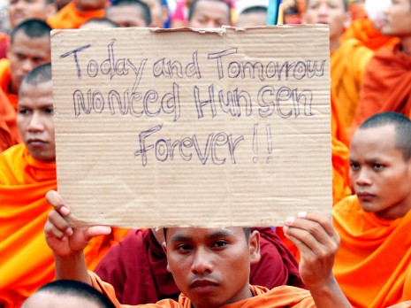 A monk holds up a placard on the final day of the Cambodia National Rescue Party's three-day demonstration against voting irregularities at Phnom Penh's Freedom Park on Tuesday. (Siv Channa)