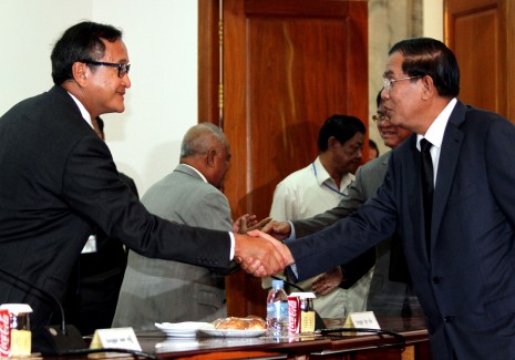 Prime Minister Hun Sen, right, shakes hands with opposition CNRP leader Sam Rainsy during negotiations at the National Assembly in Phnom Penh on Tuesday. (Siv Channa)