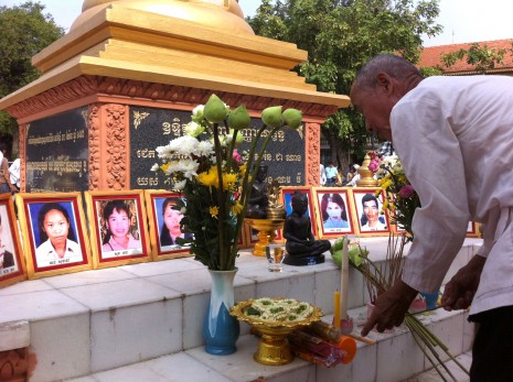 A Buddhist layman arranges offerings of incense on Monday at the memorial stupa in Phnom Penh for the victims of the 1997 grenade attack. Opposition leaders Sam Rainsy and Kem Sokha, who organized the ceremony ahead of the Pchum Ben festival, called for long-delayed justice for the more than one dozen killed and 100 injured in the still unsolved atrocity. (Kevin Doyle/The Cambodia Daily)