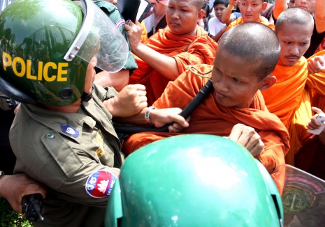 Monks force their way through a line of riot police near Wat Phnom meant to prevent anti-eviction protesters from marching to deliver a petition to City Hall on Thursday. (Siv Channa)