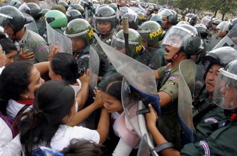 Riot police force anti-eviction activists off Phnom Penh's Monivong Boulevard Thursday after they gathered at City Hall to protest their 2012 eviction from the city's Borei Keila neighborhood. (Siv Channa)