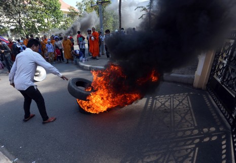 Anti-eviction protesters, along with a group of Buddhist monks, burn tires in front of Phnom Penh municipal hall on Monday, calling for governor Pa Socheatvong to meet their demands for more compensation over their eviction from the Boeng Kak area. (Siv Channa)