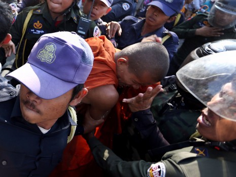Military police and Phnom Penh municipal security guards on Tuesday physically restrain and remove a monk from in front of City Hall, where anti-eviction activists and monks had gathered for a second day demanding to meet city governor Pa Socheatvong. (Siv Channa)