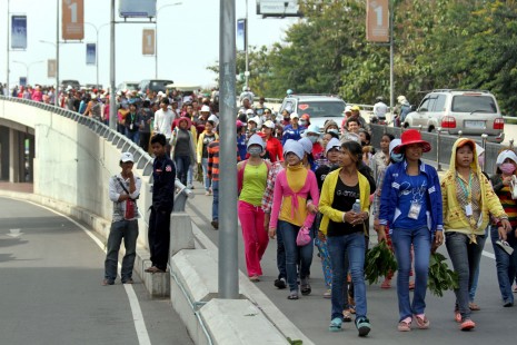 Protesting for an increase to their monthly minimum wage, garment factory workers march over the Russian Boulevard overpass Thursday morning, en route to join demonstrations at Phnom Penh's Freedom Park. (Siv Channa)
