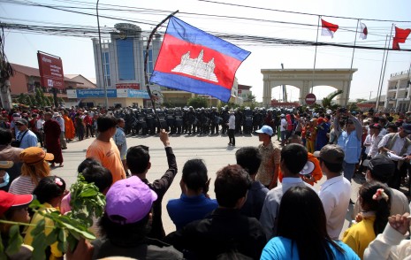Striking garment factory workers demonstrate on Friday in front of a line of military police guarding the entrance to the Phnom Penh Special Economic Zone as protests intensify for a monthly wage of $160. (Siv Channa)