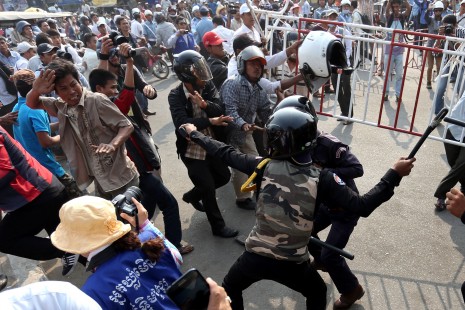 Daun Penh district security guards attack a group of protesters at a demonstration in Phnom Penh on Sunday calling for the release of 23 activists and workers arrested earlier this month. (Siv Channa)