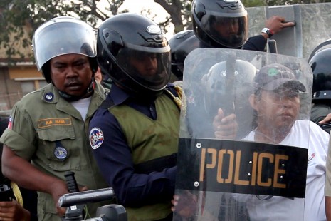 Union leader Sok Chhun Oeung, right, is dragged away Sunday by riot police and district security guards during a small gathering on the Phnom Penh riverside to call for the release of detained fellow union leader Vorn Pao, who was among 23 people beaten and detained by military police and paratroopers during garment strike protests earlier this month. (Siv Channa)