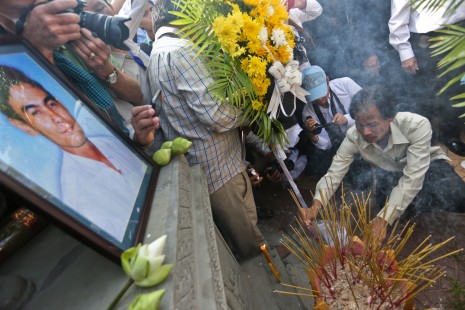 Free Trade Union president Chea Mony, right, lights incense in front of a memorial statue in Phnom Penh built in honor of his slain brother, former FTU leader Chea Vichea, who was gunned down 10 years ago Wednesday. (Siv Channa)