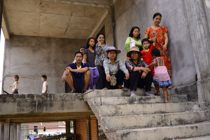 Residents in the Borei Keila area of Phnom Penh sit on the steps of an unfinished apartment block they occupied Wednesday, following another protest over land. (Lauren Crothers/The Cambodia Daily)