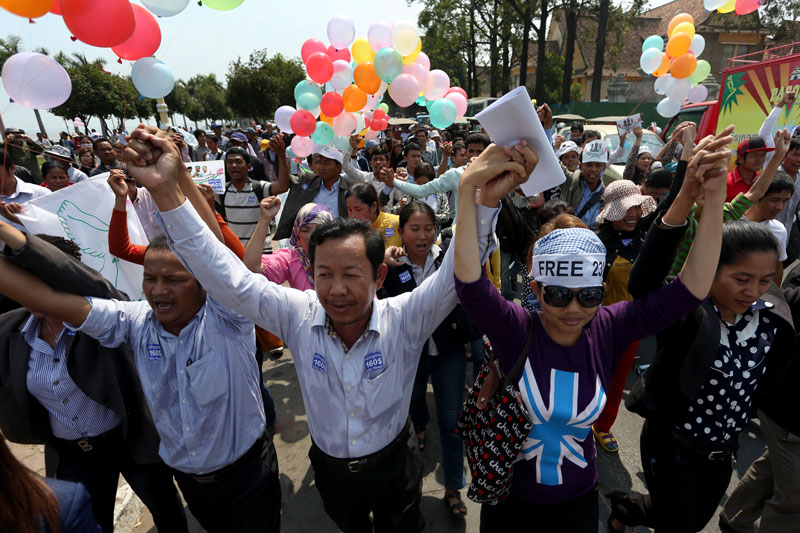 Rong Chhun, president of the Cambodian Independent Teachers Association, second left, and land rights activist Yorm Bopha, third left, march with other union members and activists along Sisowath Quay in Phnom Penh on Monday afternoon. (Siv Channa)