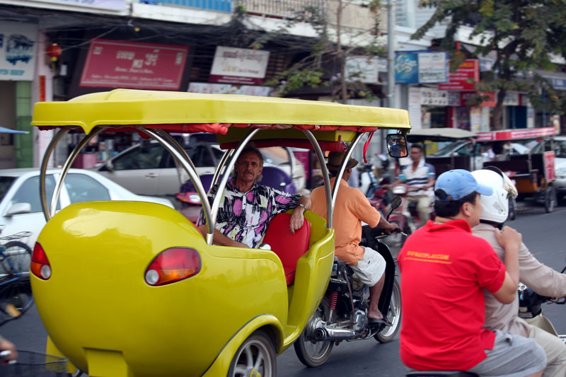 One of Bruno Brunner's futuristic tuk-tuks transports a passenger down Sisowath Quay in Phnom Penh on Tuesday. (Siv Channa)