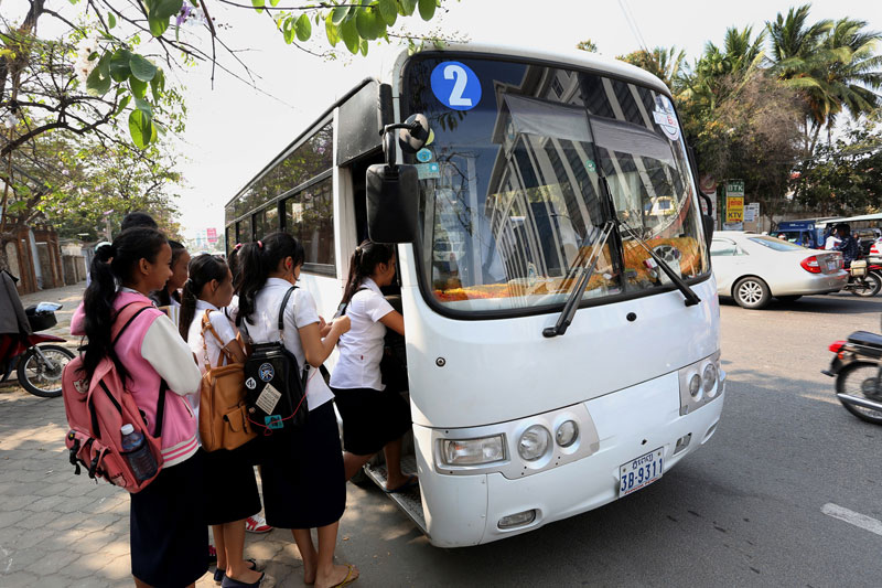 Schoolchildren queue up to board the Number 2 city bus on Monivong Boulevard in Phnom Penh on the first day of a monthlong trial of a municipal bus service on Wednesday. (Siv Channa)