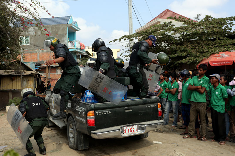Riot police deploy Wednesday at the garbage truck depot of the city's waste disposal firm, Cintri, in Dangkao district, where hundreds of workers were striking for better working conditions and higher wages. (Siv Channa)