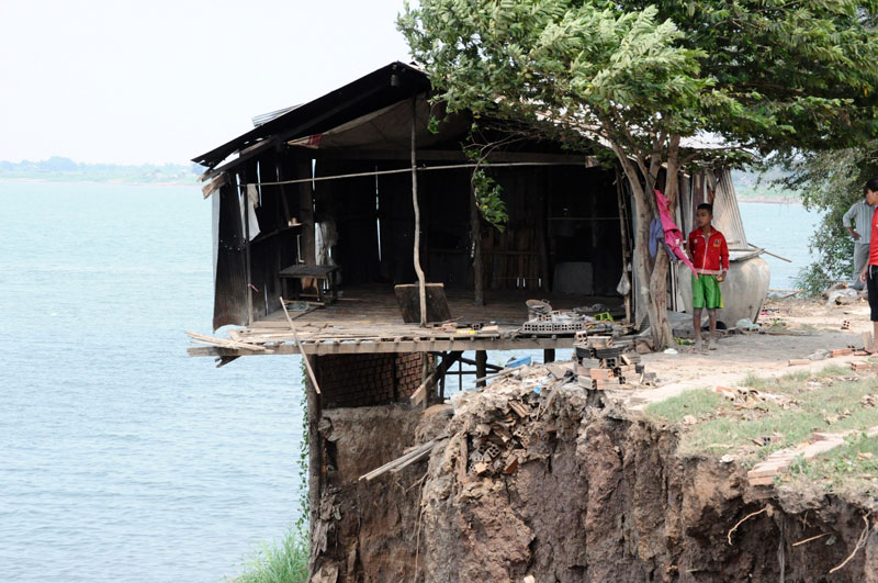 A house stands at the edge of the Mekong River in Khsach Kandal district's Preah Prasap commune in Kandal province after a riverbank collapse caused adjoining houses to fall into the river on Tuesday. (Simon Henderson/The Cambodia Daily)