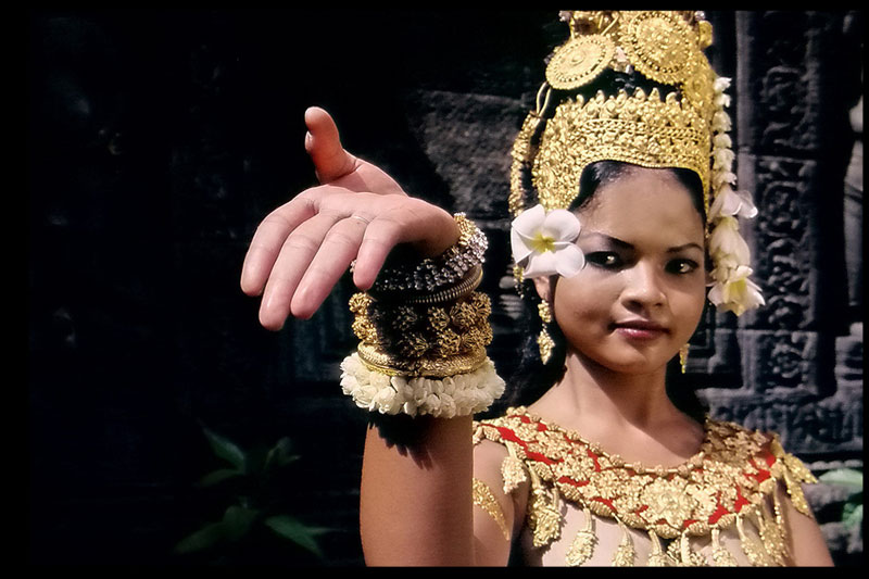 A modern day Khmer classical dancer wearing a headdress nearly identical to one sculpted on the Bayon monument in Angkor Archeological Park (Arjay Stevens)