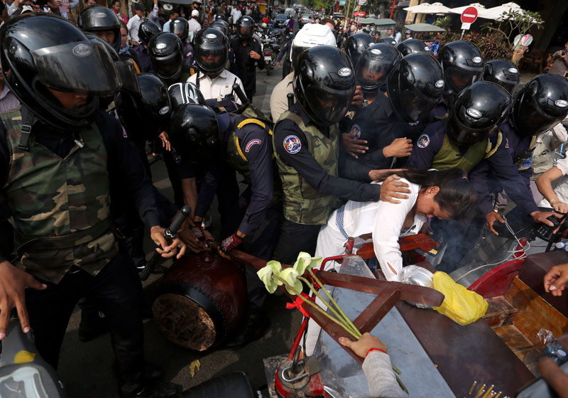 Daun Penh district security guards push aside protesters and seize a ceremonial drum that was being played at a police roadblock Monday on Phnom Penh's Sisowath Quay. The protesters were calling for the release of 21 people who were beaten and jailed during strike demonstrations in January. (Siv Channa)