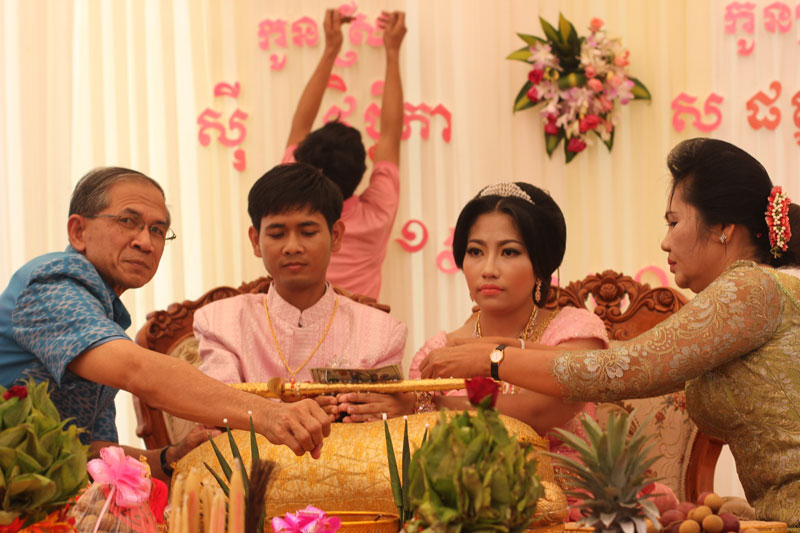 Sar Patchata and her new husband, Sy Vicheka, are flanked by her stepfather, Tep Khunnal, and her mother, Mea Som, during the young couple's wedding celebration Monday. (Alex Willemyns/The Cambodia Daily)