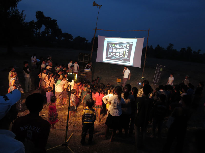 Families in Siem Reap City's Nokor Thom commune gather in a field on Sunday to watch a screening of the Japanese animated movie "Hal's Flute." (Create A Theater in Cambodia)
