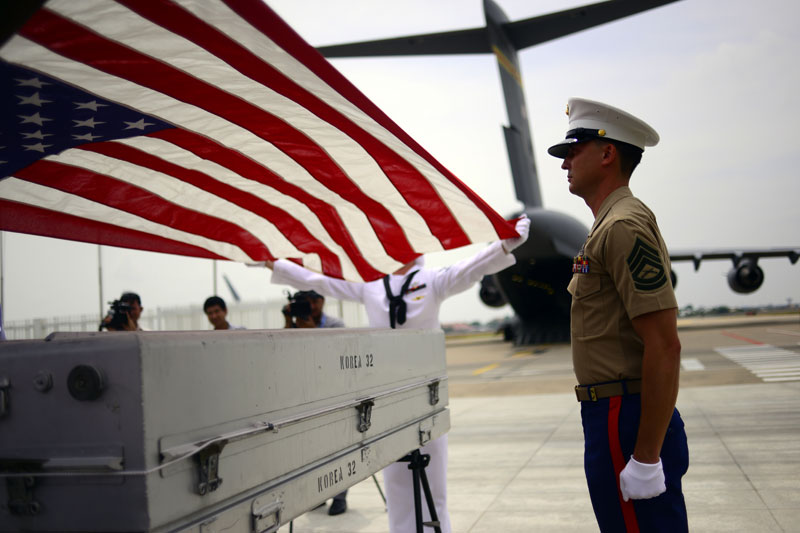 A U.S. honor guard performs a ceremonial flag service for the remains of three people, believed to be American servicemen, recovered in Kompong Cham province. The remains were handed over by Cambodia on Wednesday in a ceremony at Phnom Penh International Airport presided over by Sieng Lapresse, the first vice-chairman of the Cambodia Prisoner of War/Missing in Action Committee, and U.S. Ambassador William Todd. (Lauren Crothers/The Cambodia Daily)