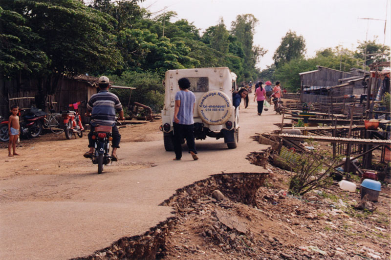 This photo taken in the early 2000s shows the heavy damage caused to National Road 11 in Prey Veng province during the 2000 floods that devastated the country. This 1970 jeep was Mr. Gascuel’s vehicle at the time. (Alain Gascuel)