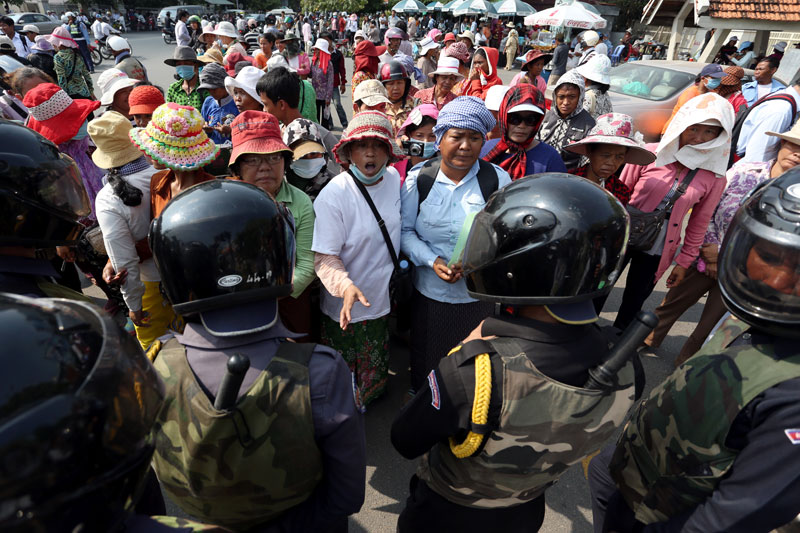 A group of evictees protest in front of a line of district security guards near Phnom Penh City Hall yesterday. (Siv Channa)