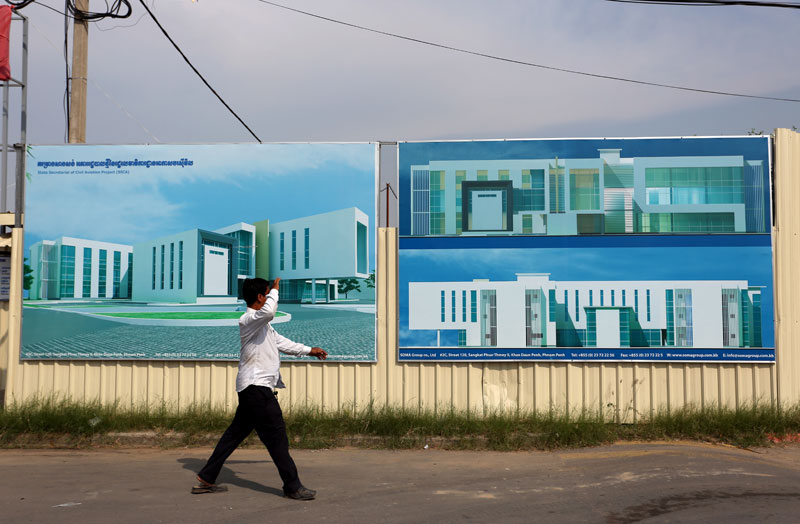 A man walks past the future site of the State Secretariat of Civil Aviation adjacent to the international airport on Russian Boulevard. (Siv Channa)